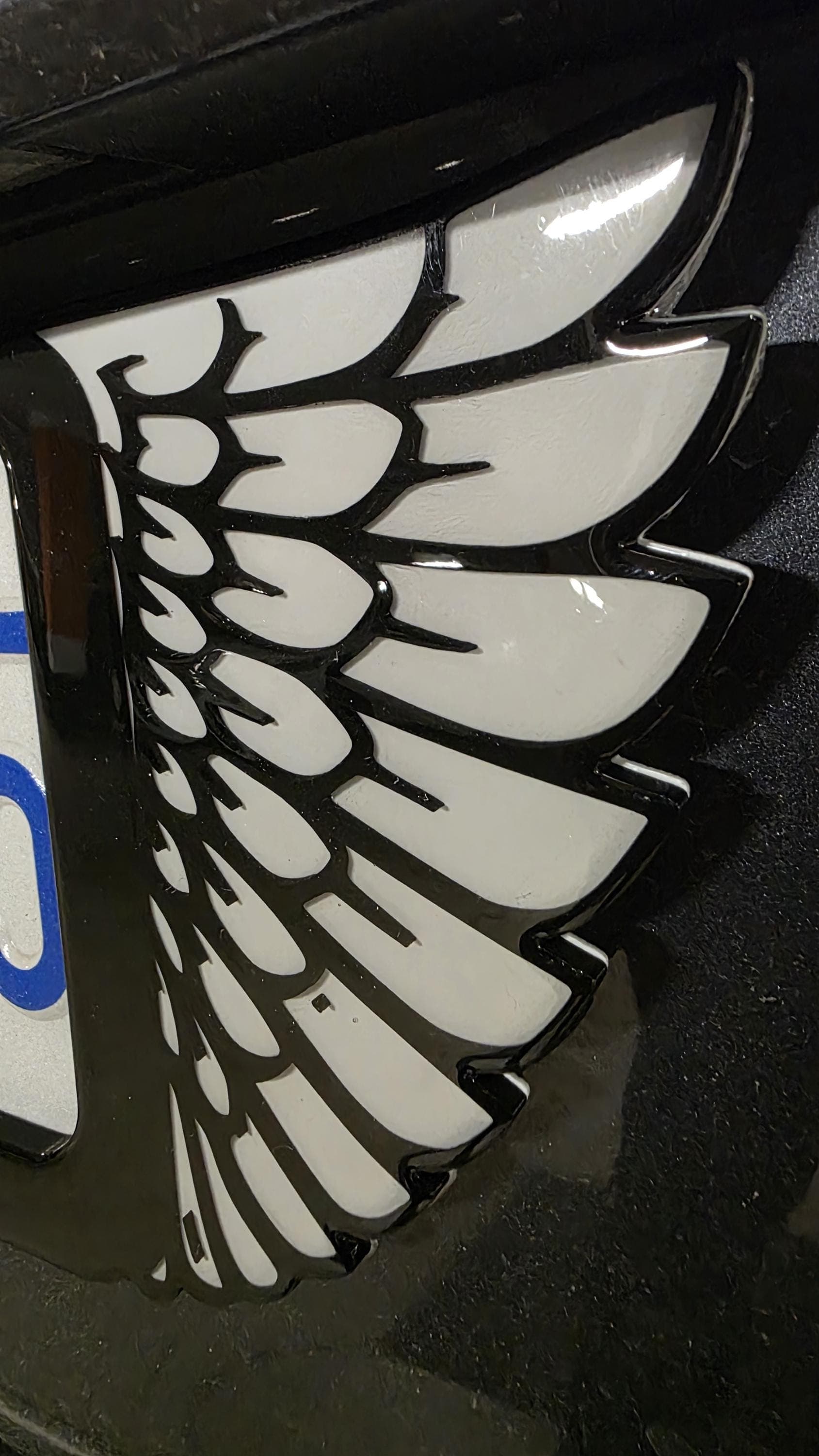 Close-up of the hand-poured epoxy finish on a Wing license plate frame